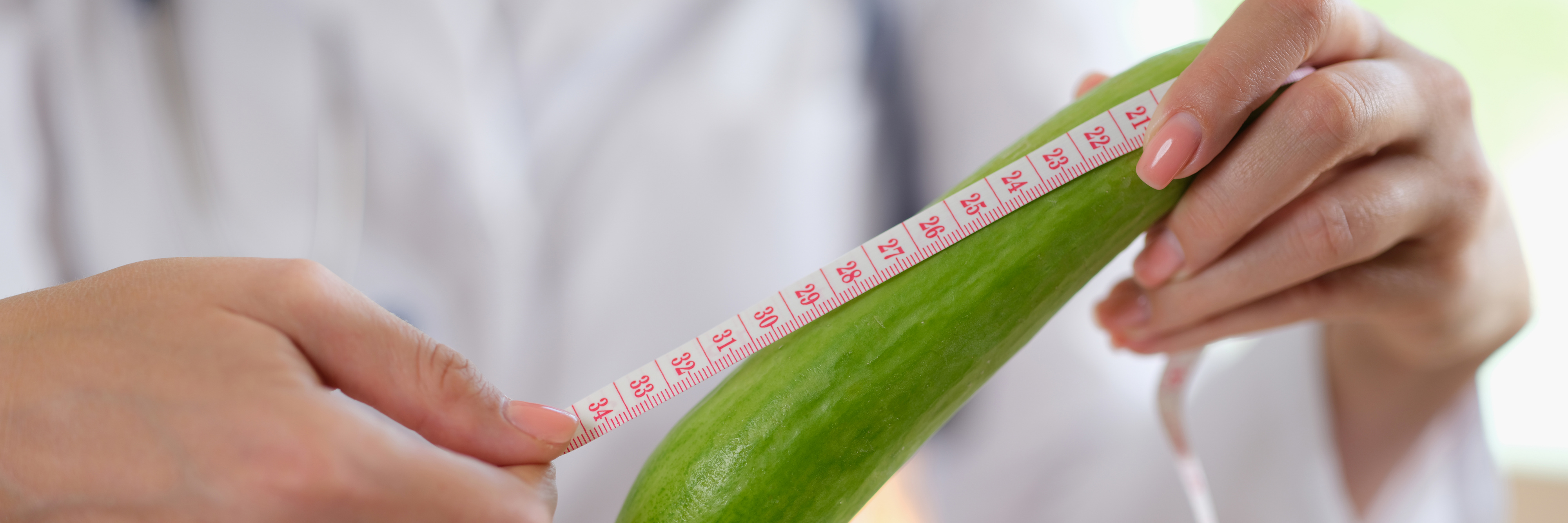 Doctor Urologist and Andrologist Holds a Centimeter of Fresh Cucumber
